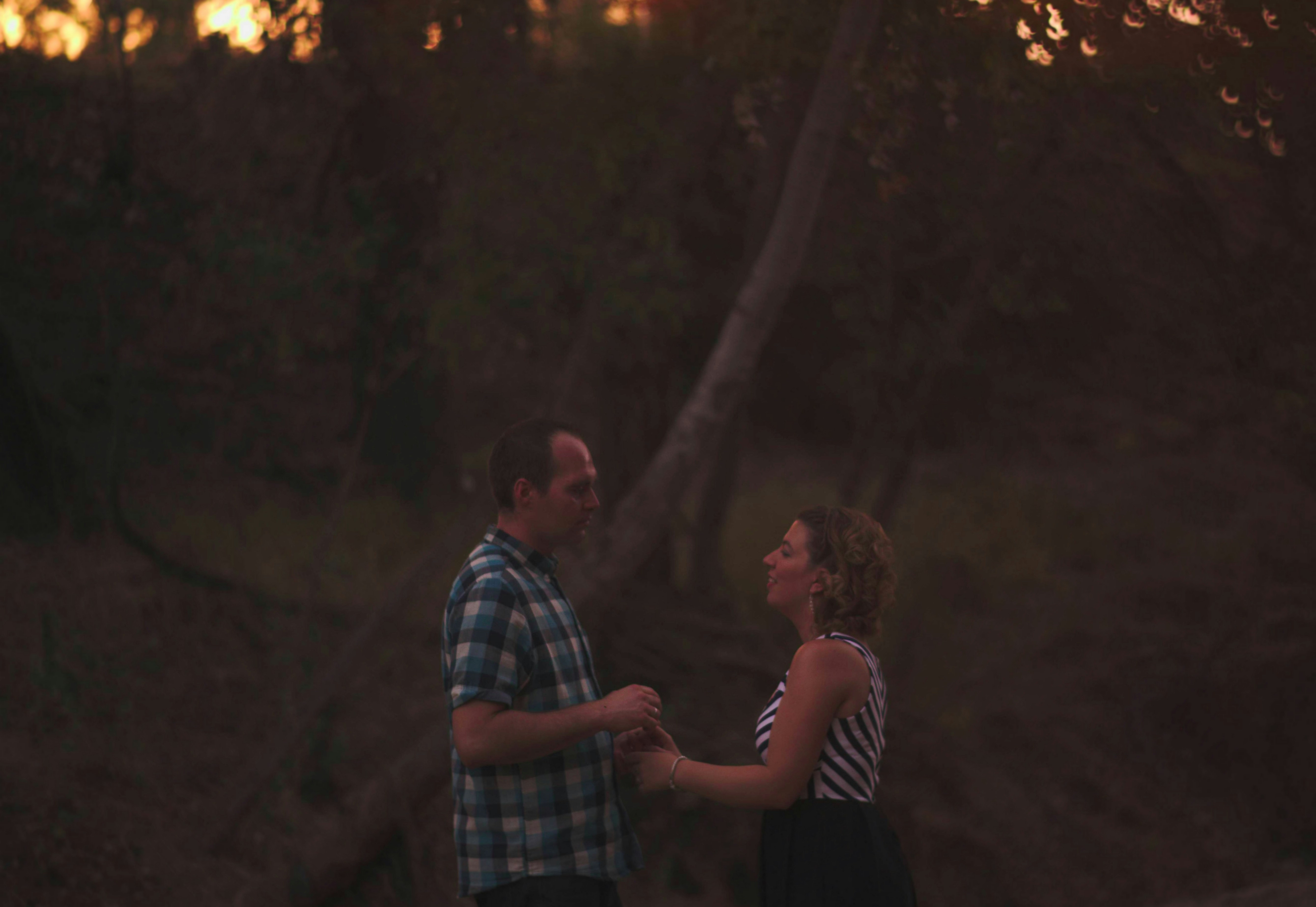 Romantic couple silhouette in warm sunset light with soft bokeh