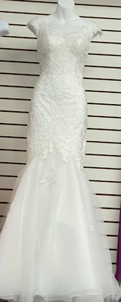 Elegant white blouse with subtle ruffles on the sleeves, showcased on a mannequin.