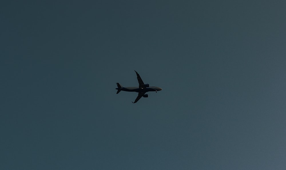 white airplane in mid air during daytime