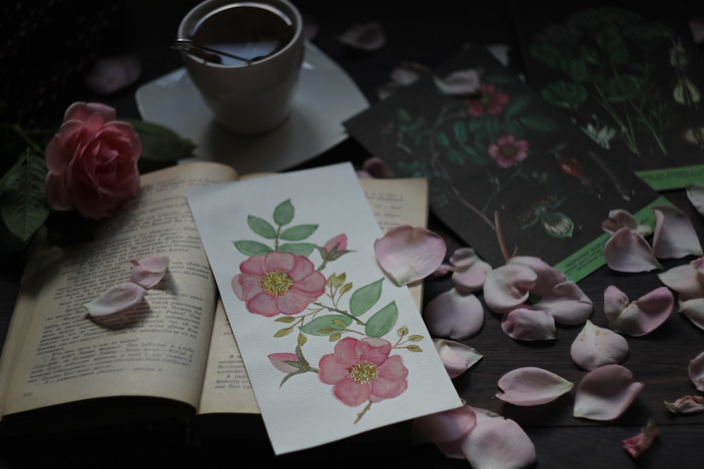 person holding white and pink floral greeting card