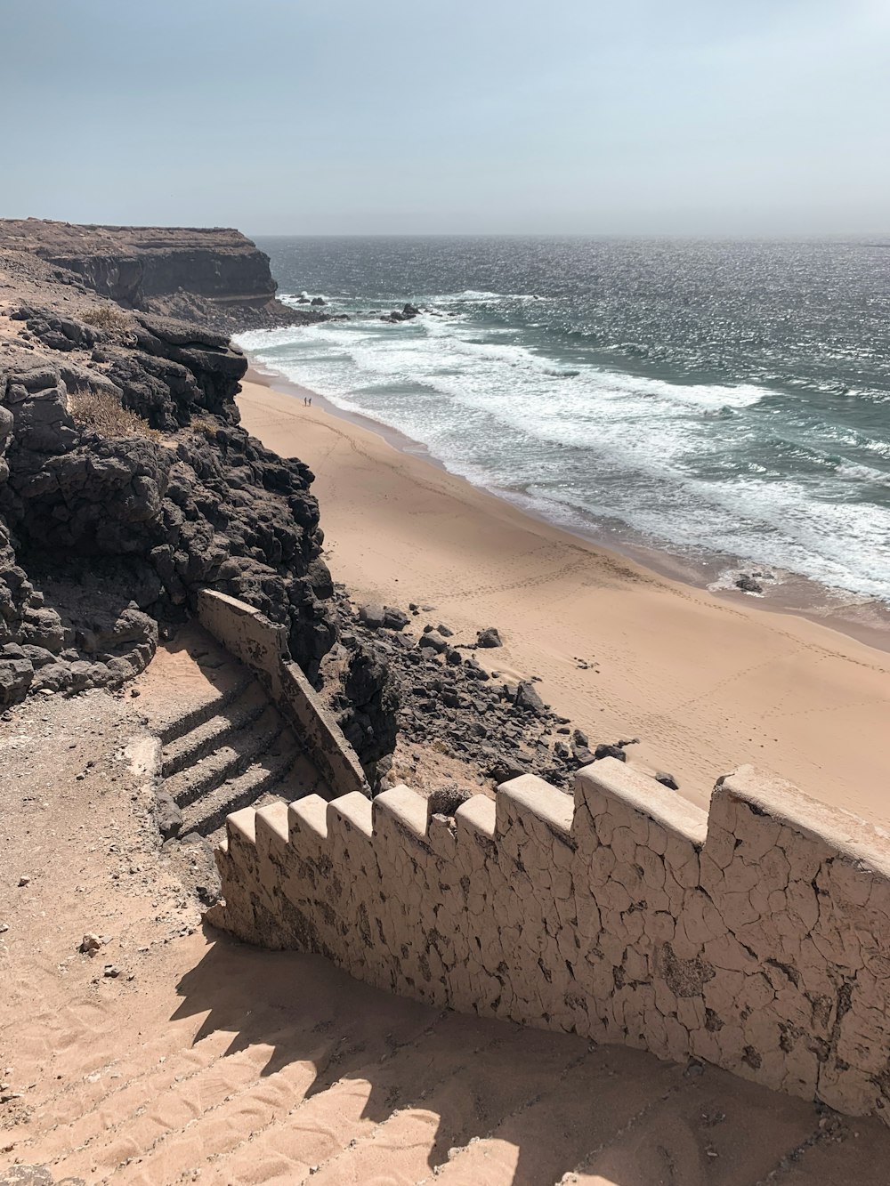 brown concrete blocks near body of water during daytime