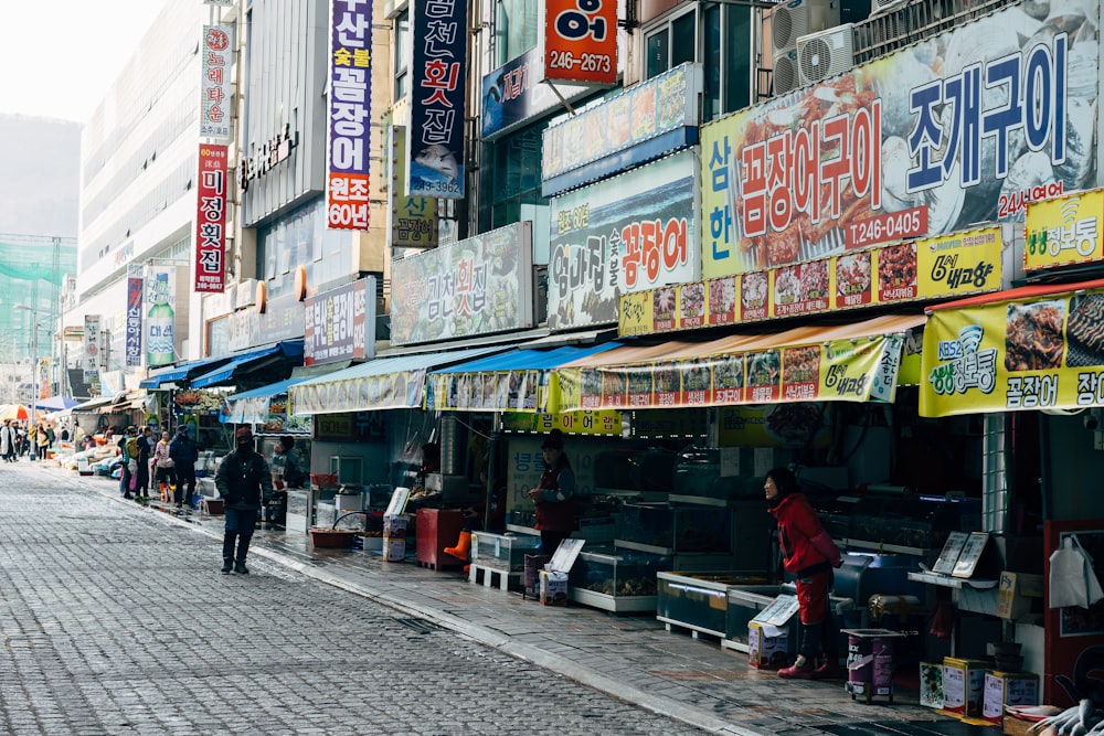 people walking on sidewalk near store during daytime