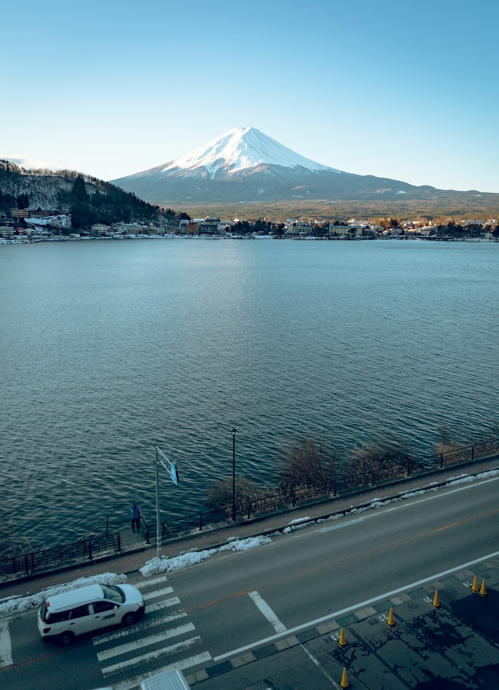 gray concrete road beside body of water during daytime