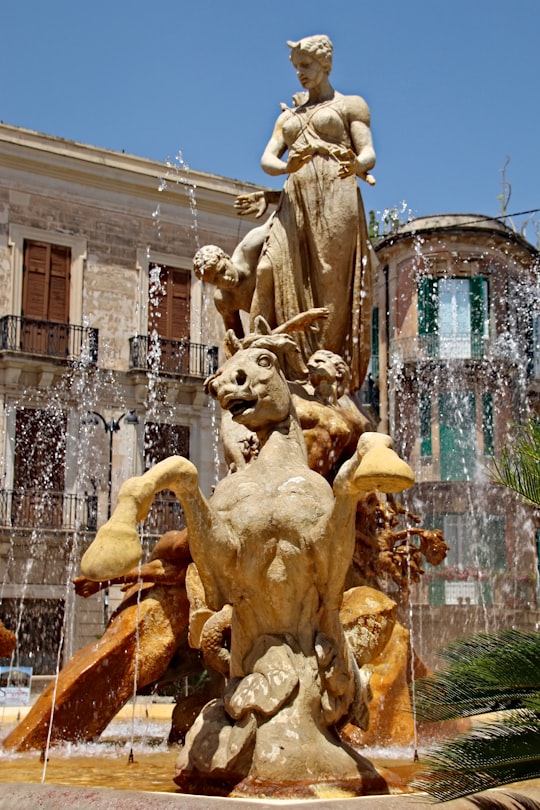 gold statue fountain during daytime in Siracusa Italy