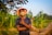 man in brown crew neck t-shirt wearing brown hat sitting on brown rock during daytime