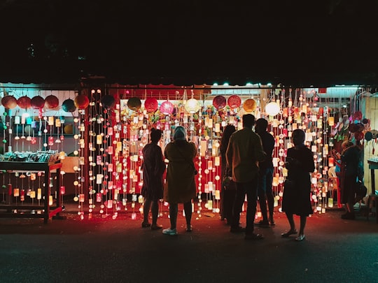 people in black suits standing on red and white string lights in Pondicherry India