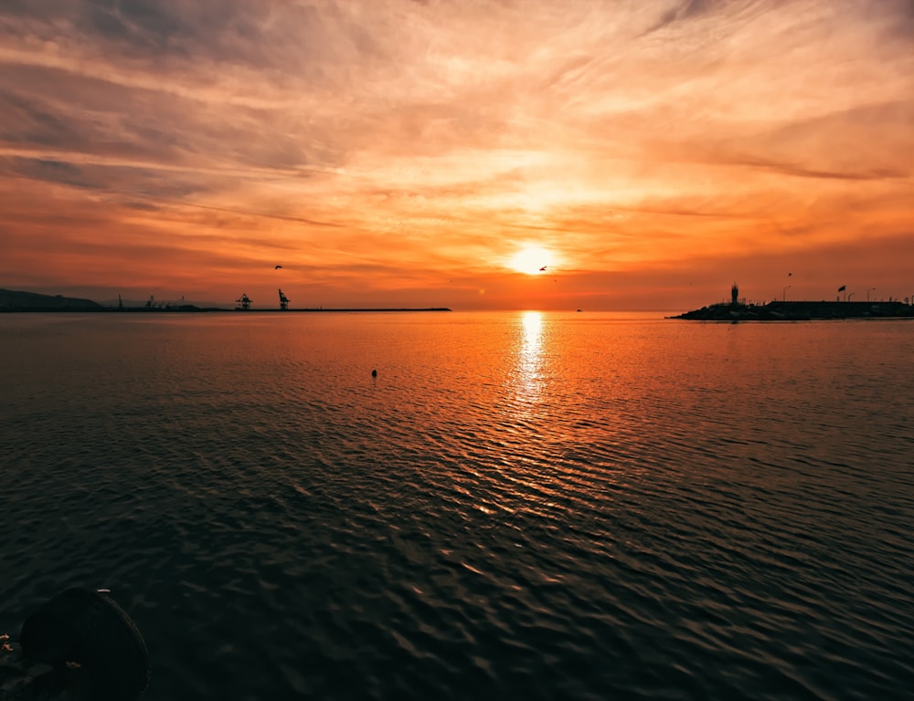 silhouette of boat on sea during sunset