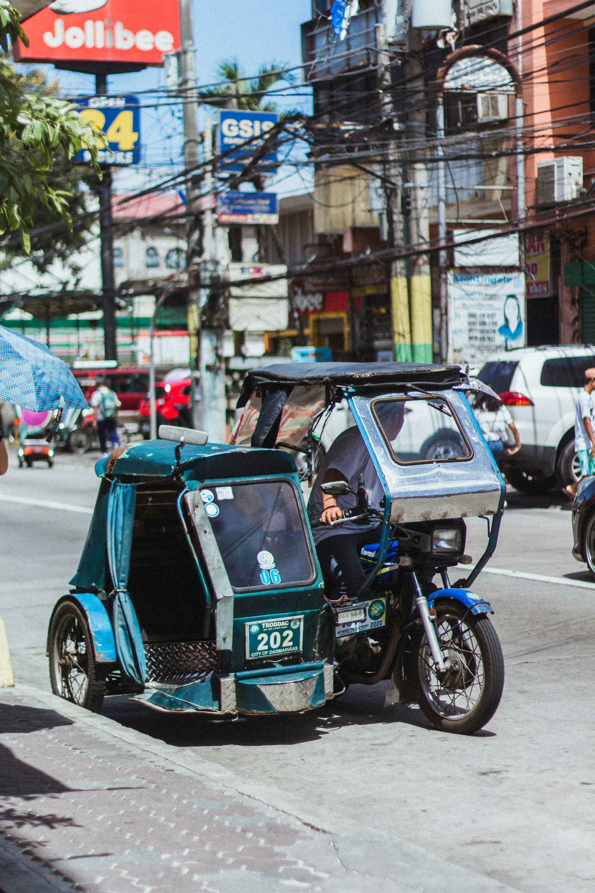 A tricycle driver in the Philippines stops to wait for a passenger.   