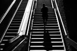 A silhouette of a lone figure standing before a grand staircase, representing strategic ascent.