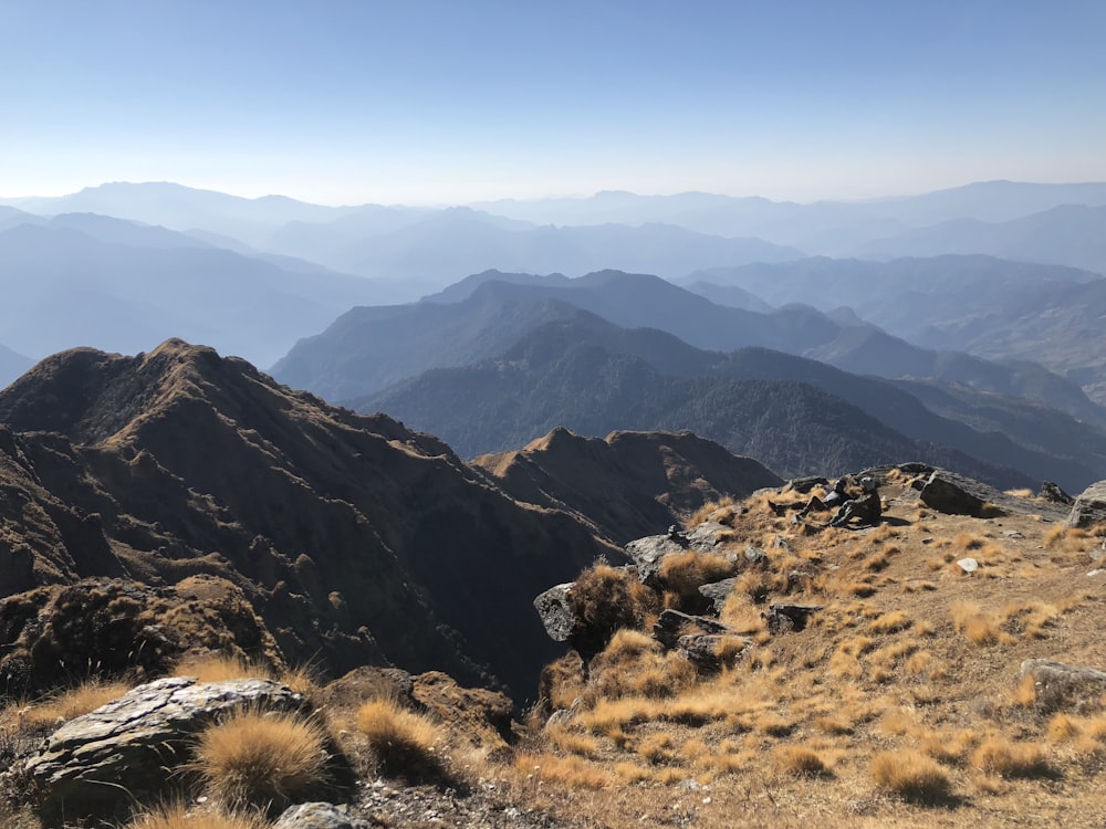 montagnes brunes et vertes sous ciel bleu pendant la journée