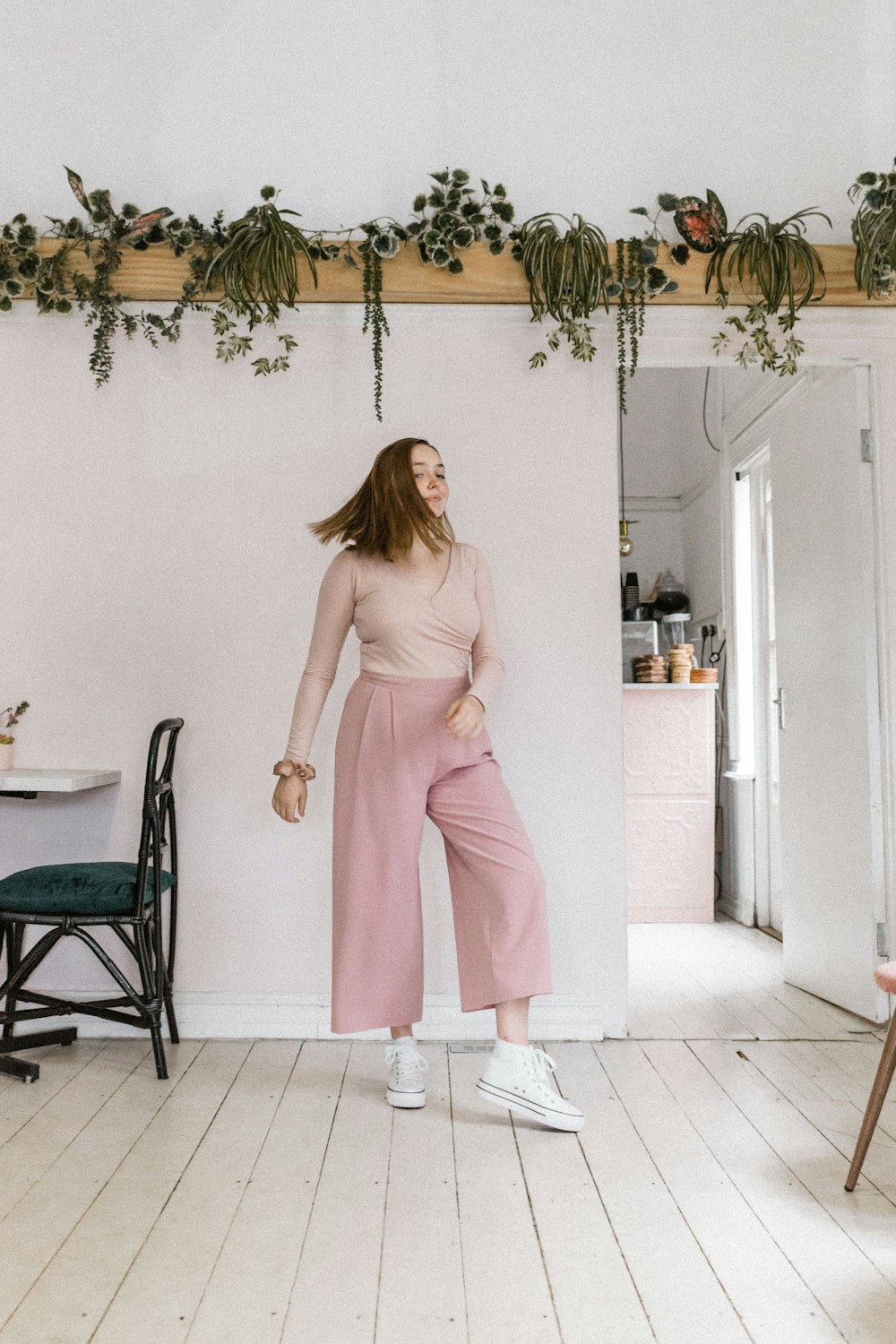 woman in pink long sleeve dress standing near white wall