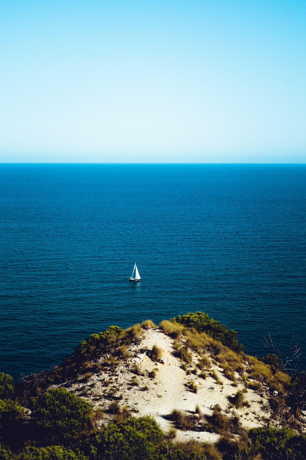 Velero blanco en el mar azul bajo un cielo blanco durante el día