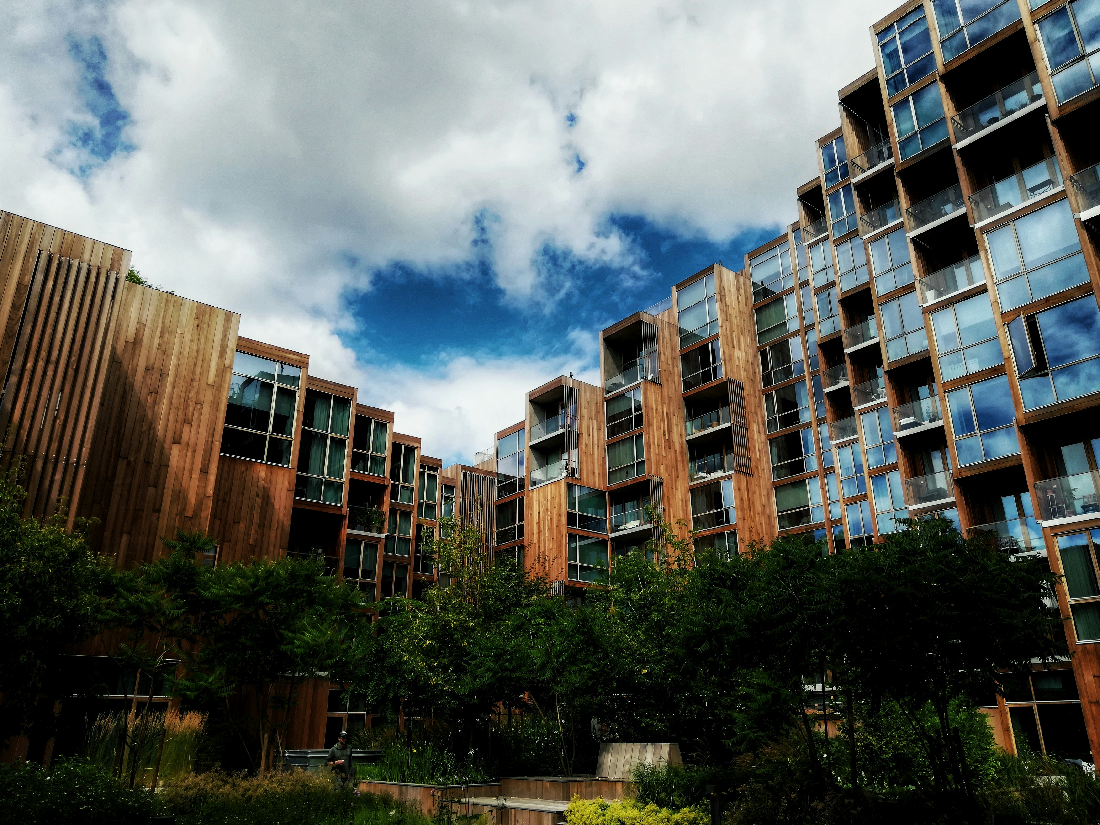 Braunes Betongebäude in der Nähe von grünen Bäumen unter blauem Himmel tagsüber