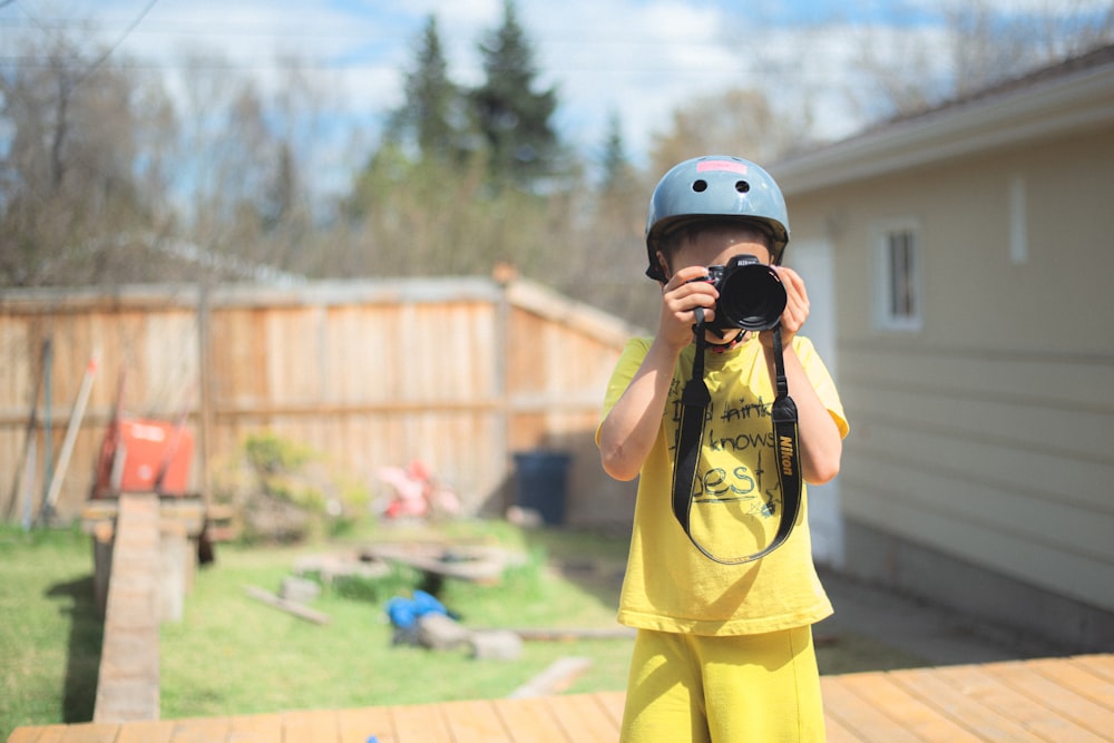 girl in yellow tank top and yellow shorts wearing helmet standing on brown concrete floor during