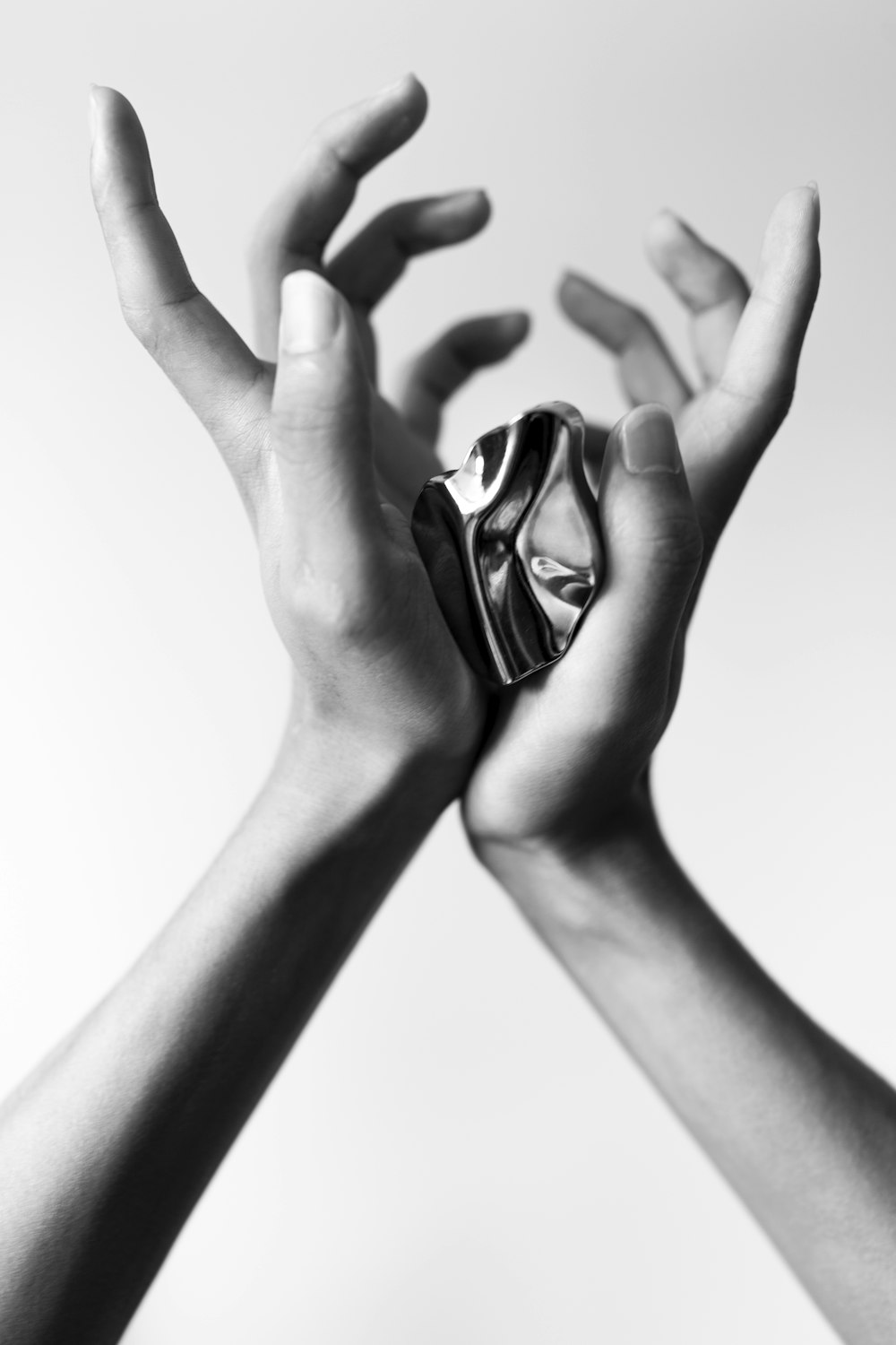 a pair of hands holding a silver object