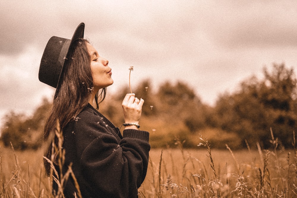 woman in black long sleeve shirt holding her hat