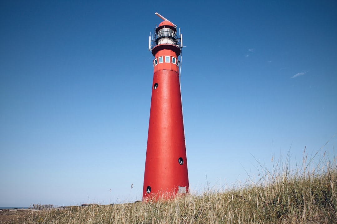 red and white lighthouse under blue sky during daytime