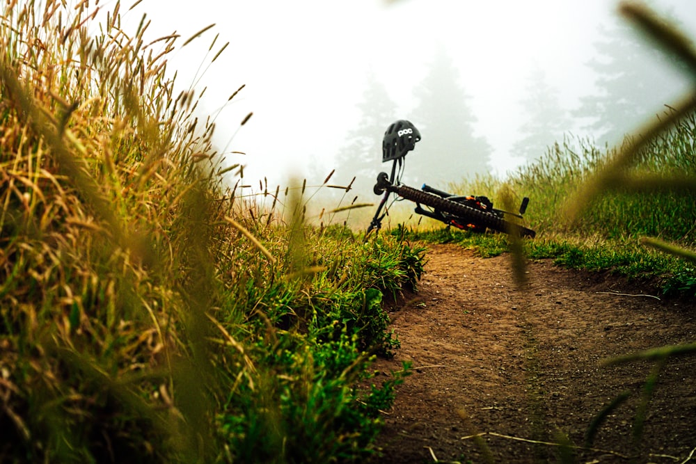 black bicycle on brown dirt road during daytime