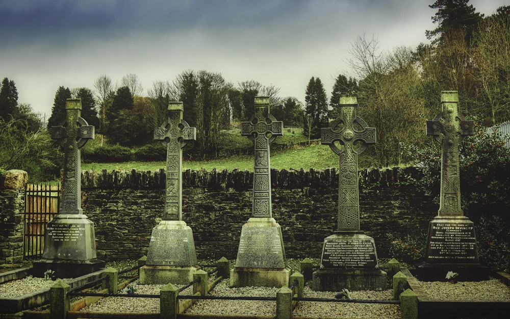 gray concrete cross statue on green grass field during daytime