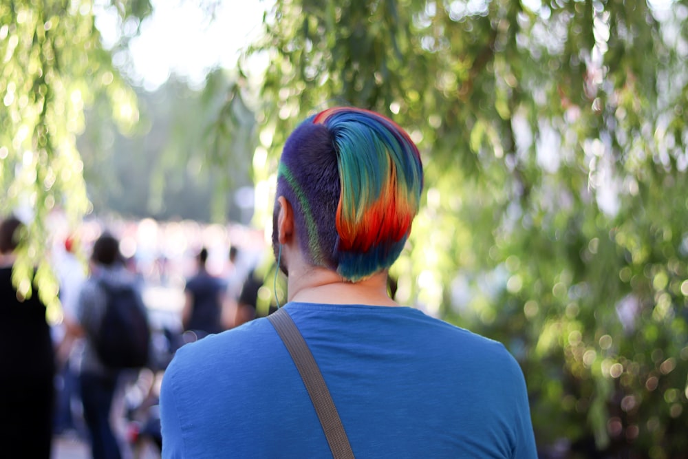 man in blue shirt with green and blue hair