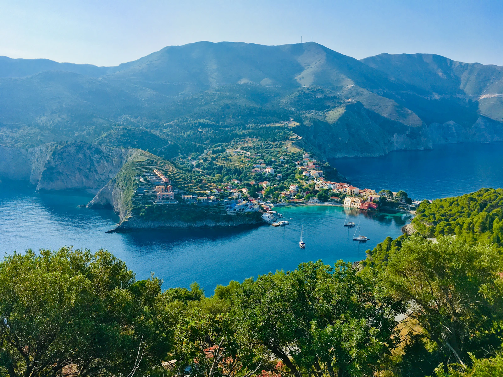 A green headland above a still bay on Karpathos