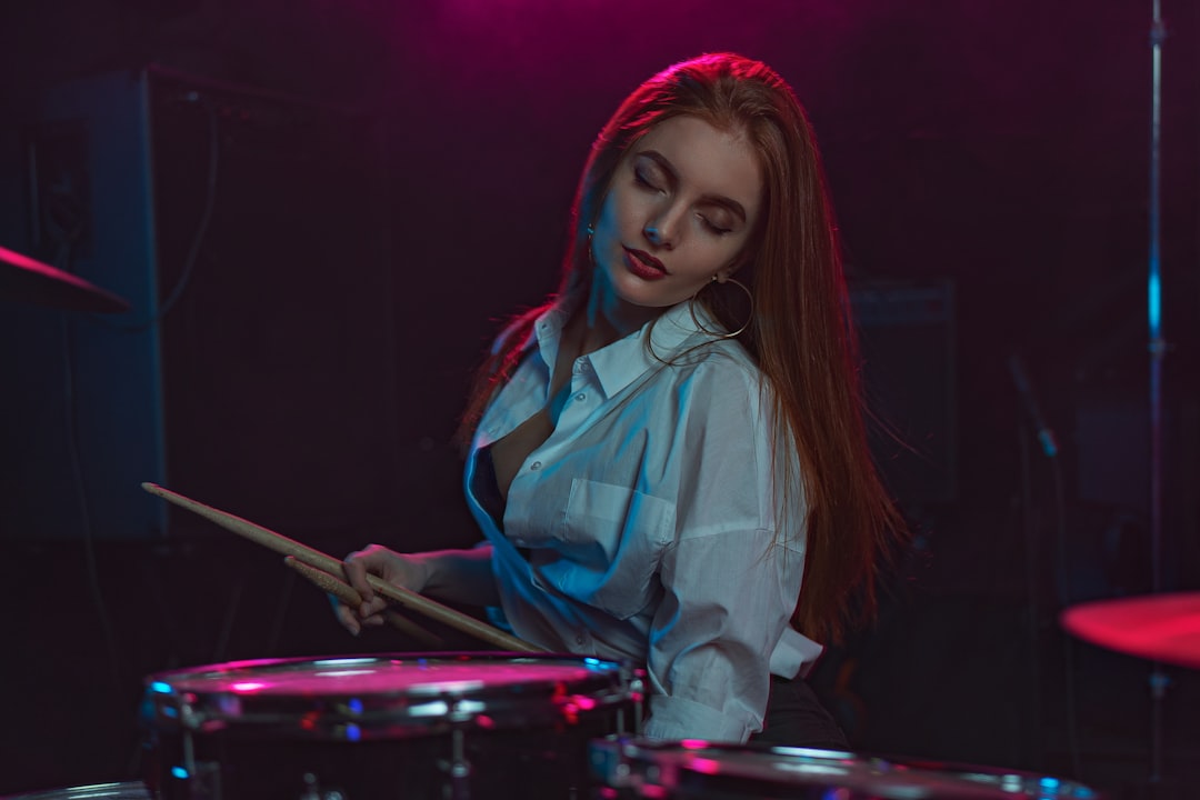 woman in white button up shirt playing drum