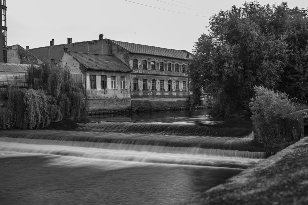 grayscale photo of house near river