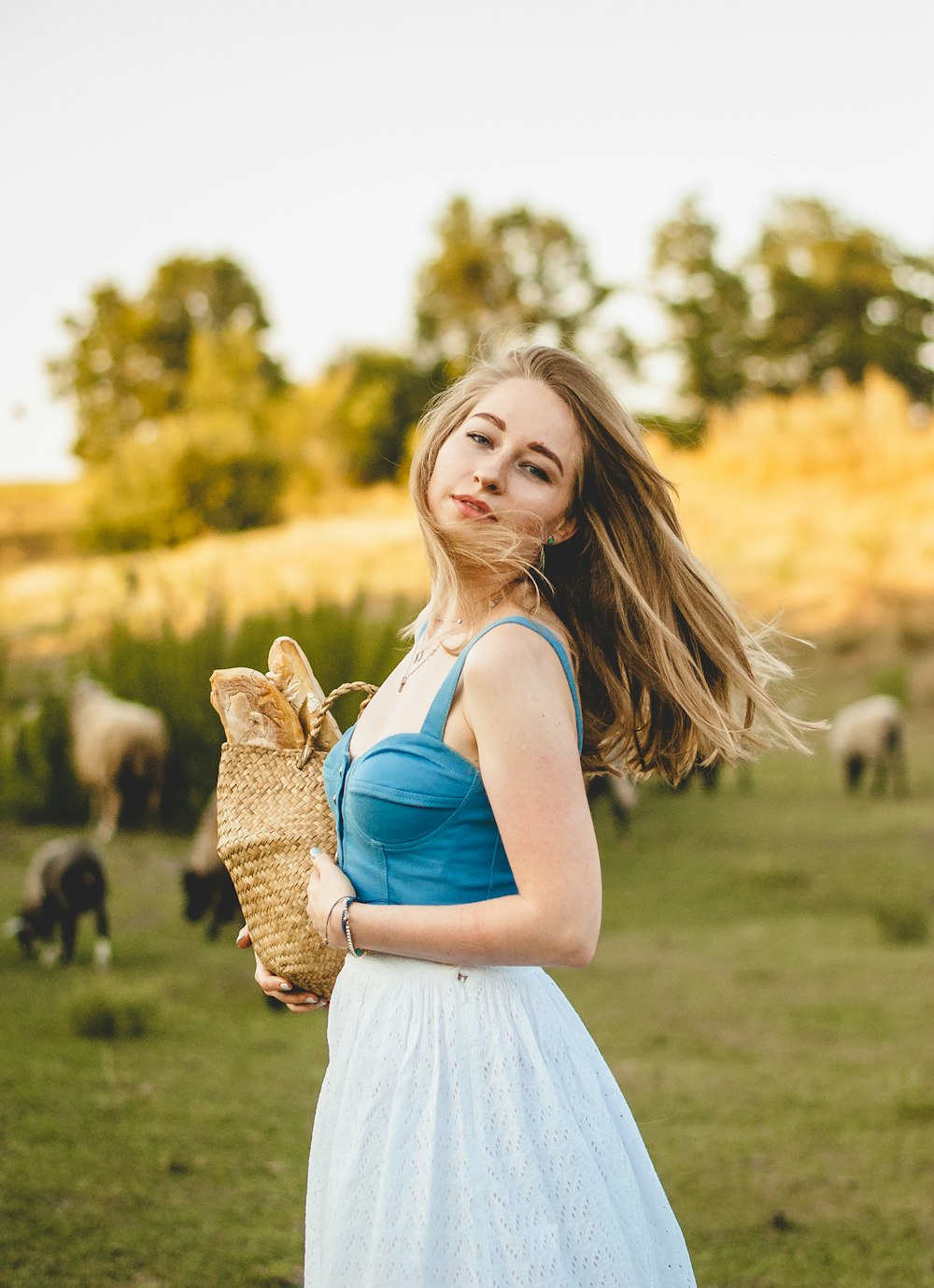 girl in white dress holding brown rabbit during daytime