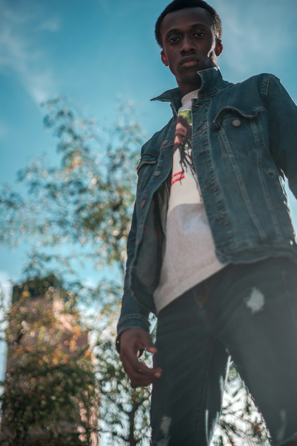 man in black denim jacket and black hat