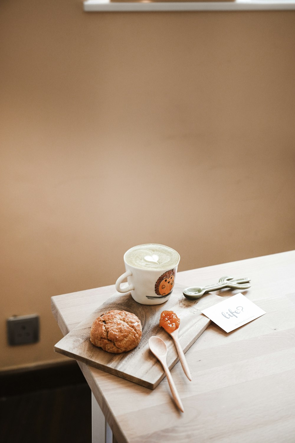 white ceramic teacup on saucer beside bread on table