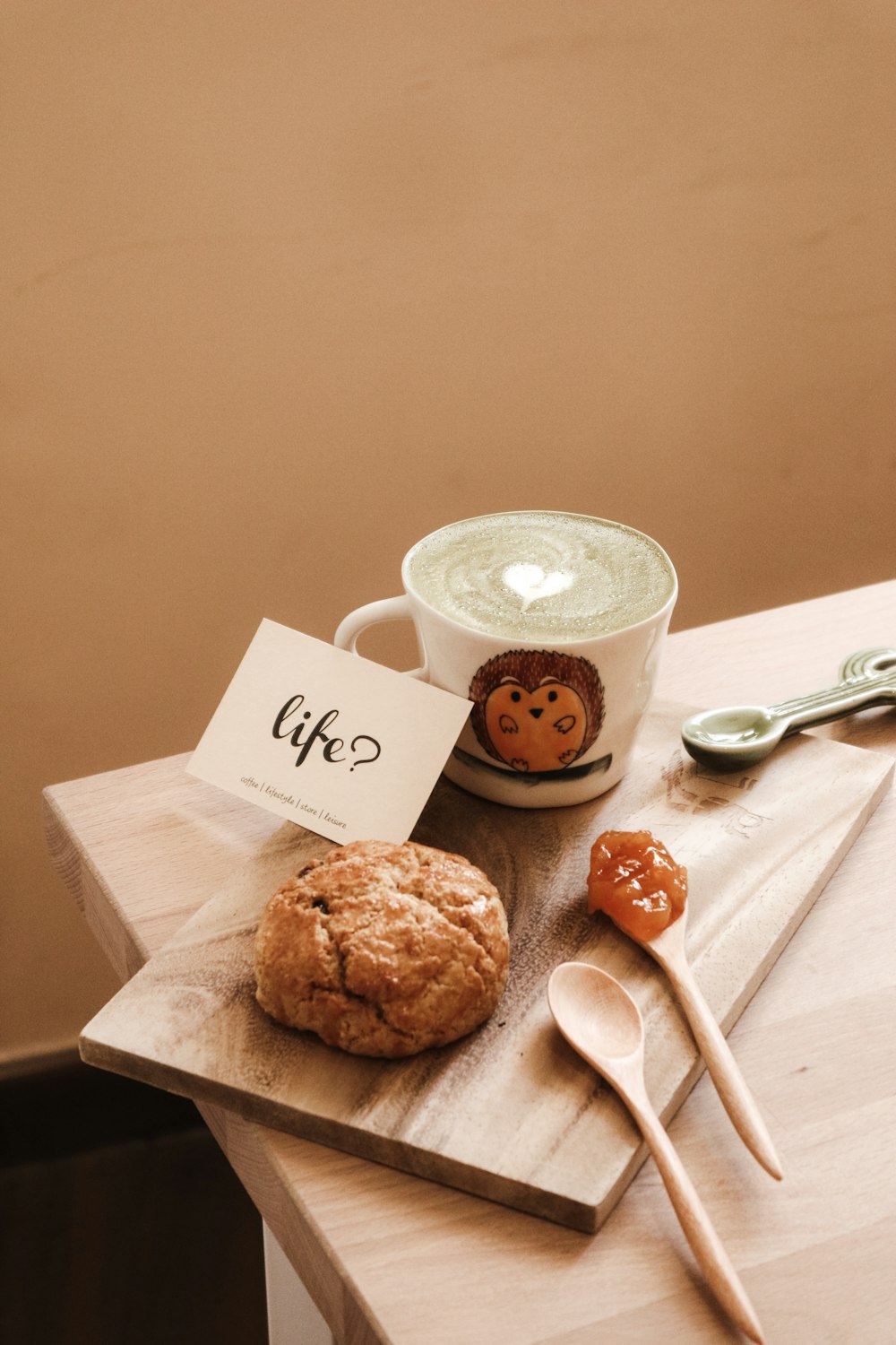 Tasse en céramique blanche à côté de biscuits bruns sur planche à découper en bois brun