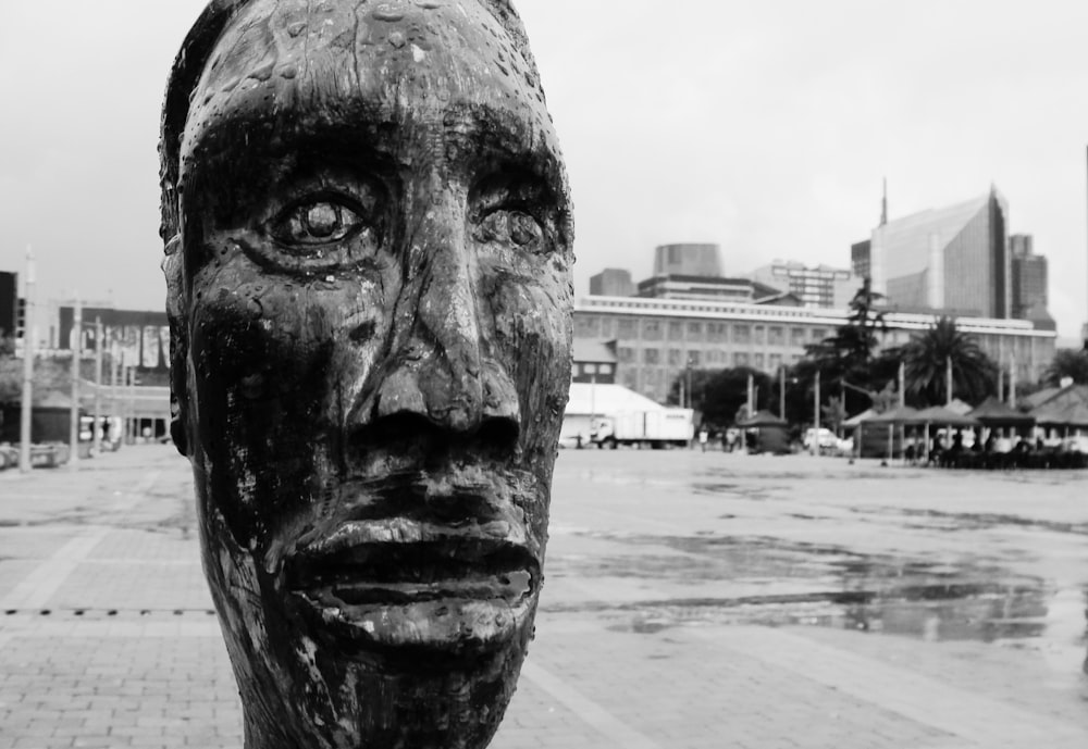 grayscale photo of mans face statue