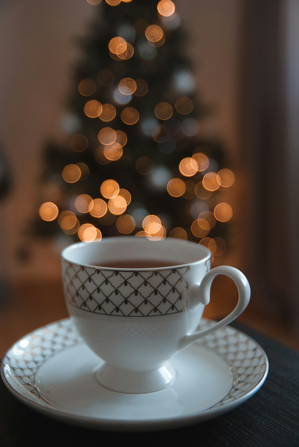 tasse à thé en céramique blanche et noire sur soucoupe en céramique blanche