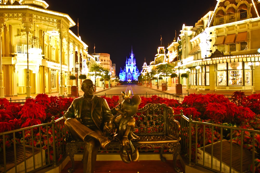 man in black jacket sitting on brown wooden bench during night time