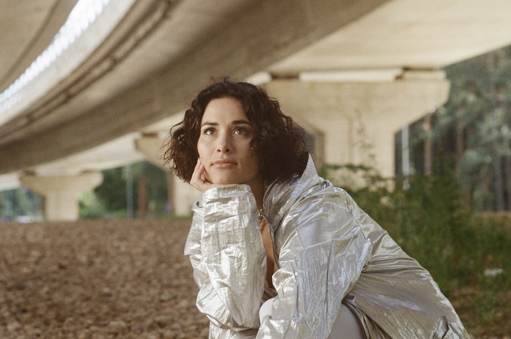 woman in white and gray dress shirt standing on brown soil during daytime