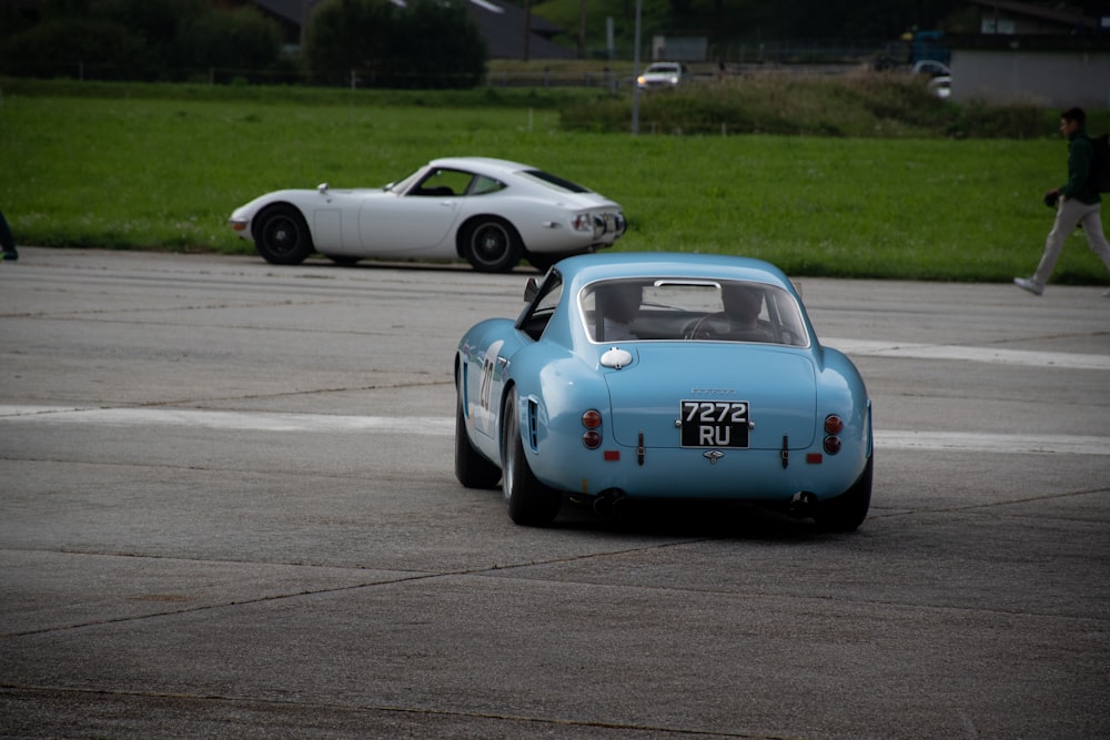 blue and white porsche 911 on road during daytime