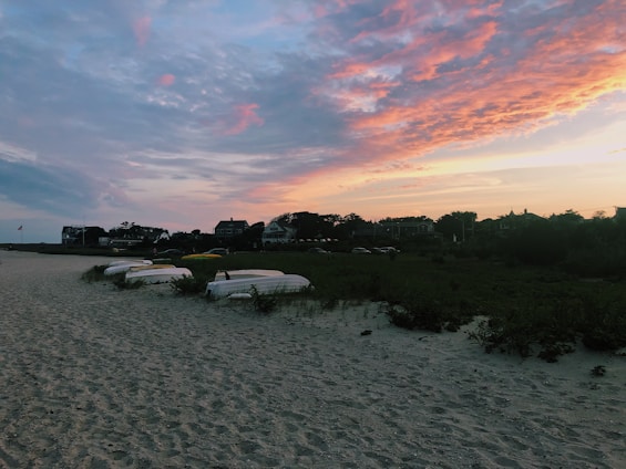 A serene beach scene at Paúba with traditional caiçara boats resting on the sand under a warm sunset.