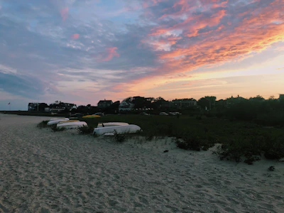 Sunset over a tranquil beach in southern Italy with colorful fishing boats.