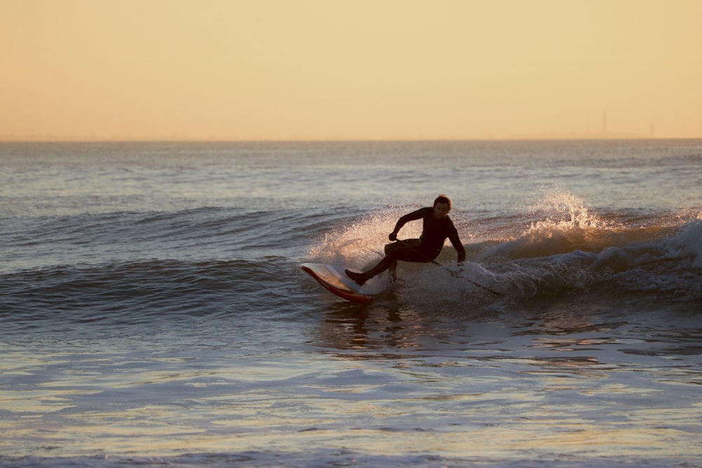 Uomo che fa surf sulle onde del mare durante il giorno