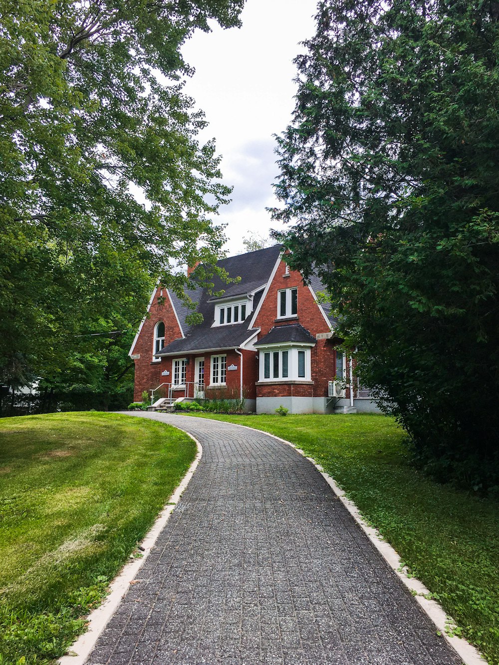 brown and white house near green trees under white sky during daytime