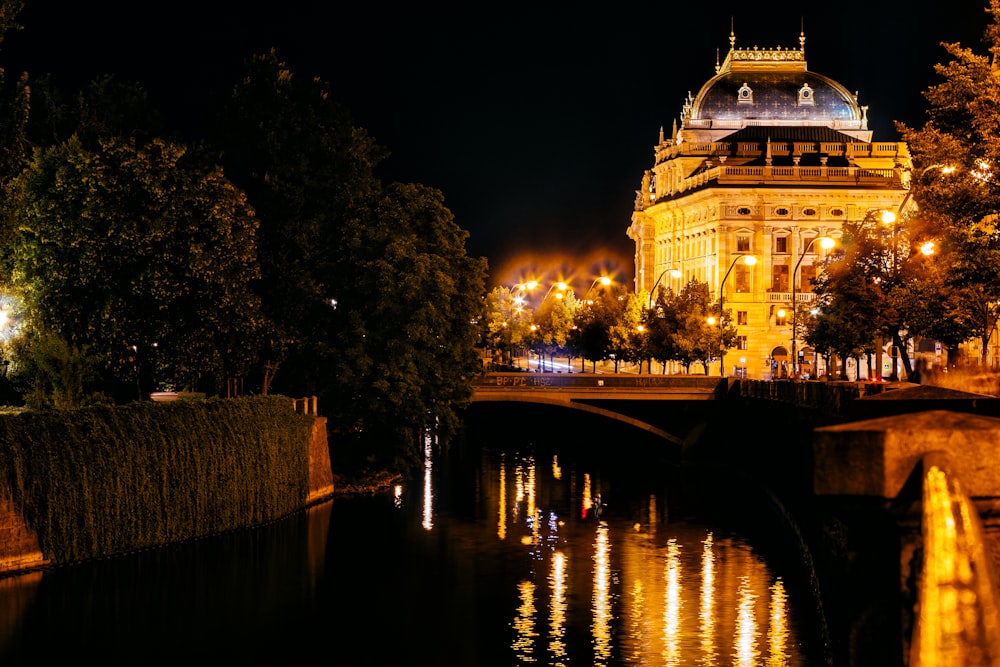 white concrete building near body of water during night time