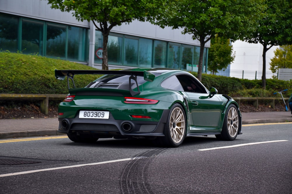 Porsche 911 verde estacionado na estrada durante o dia