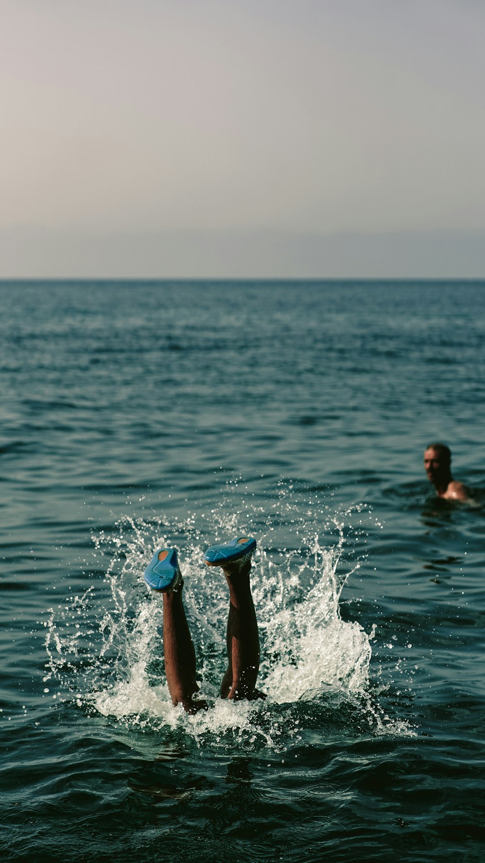 person in blue shorts in water during daytime