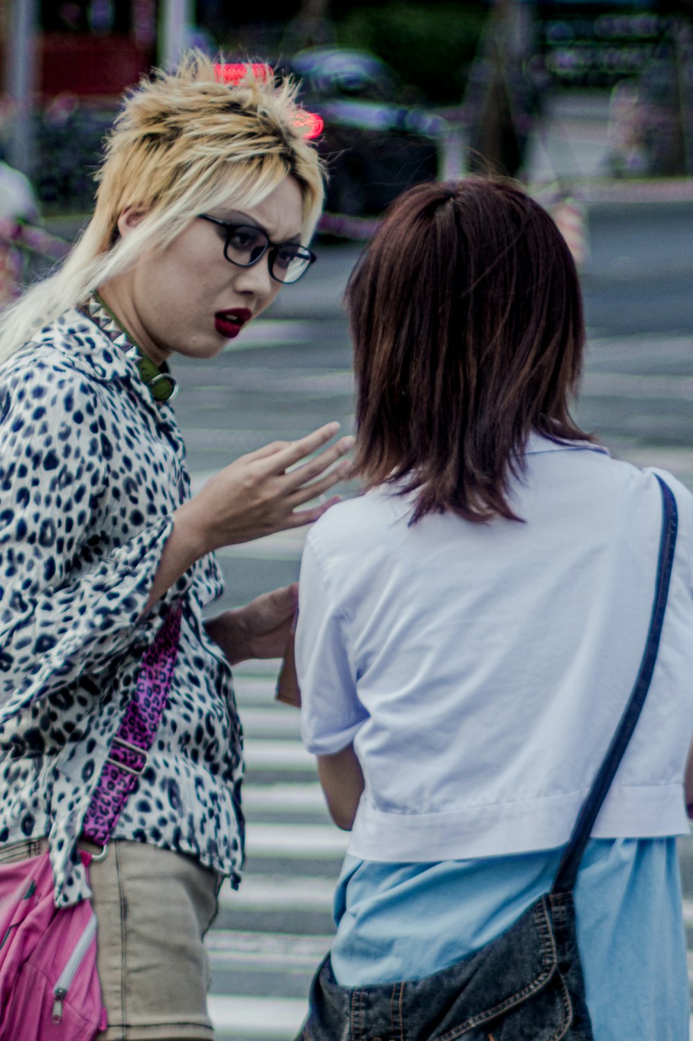 woman in white shirt holding woman in black and white leopard print shirt