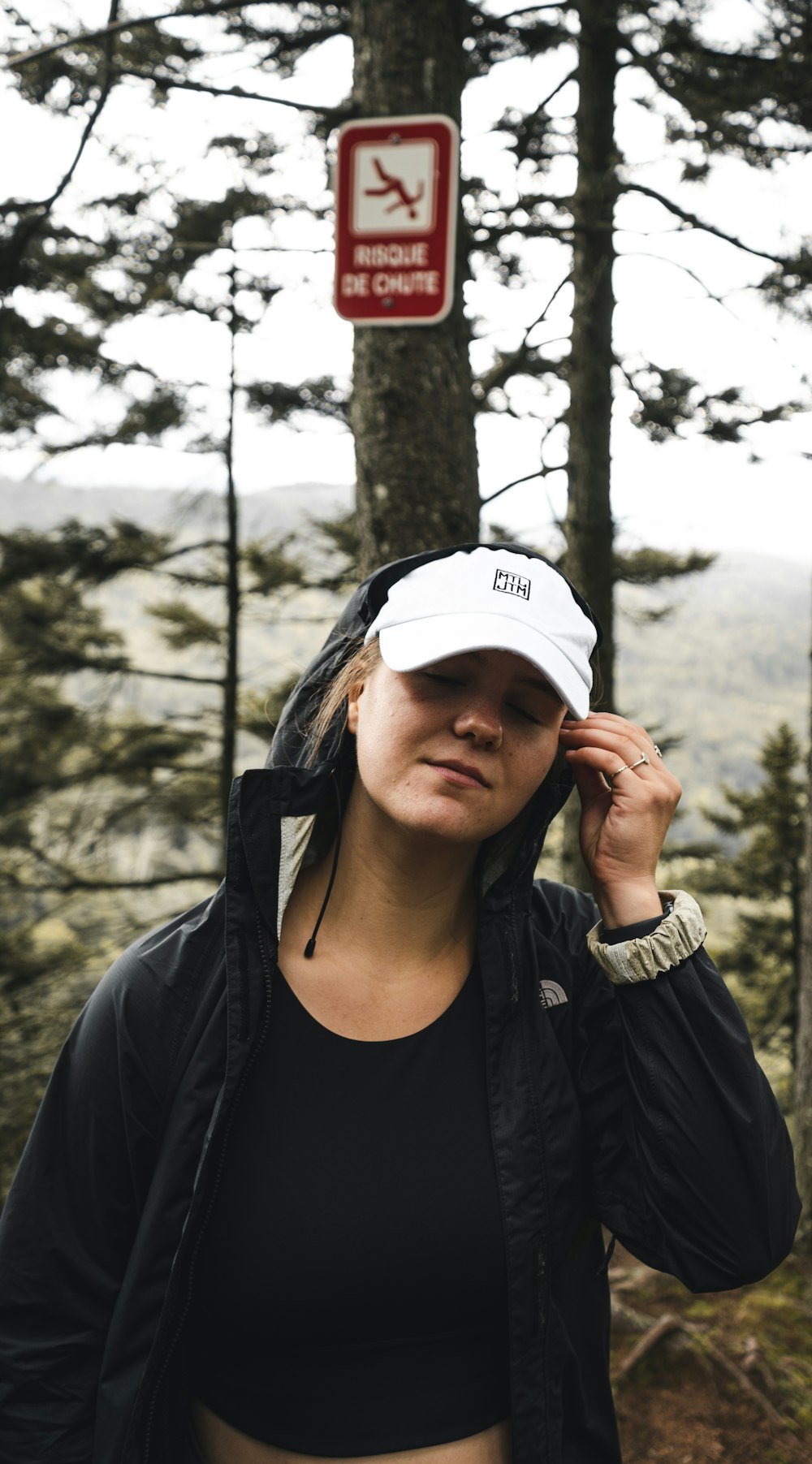 woman in black jacket wearing white cap