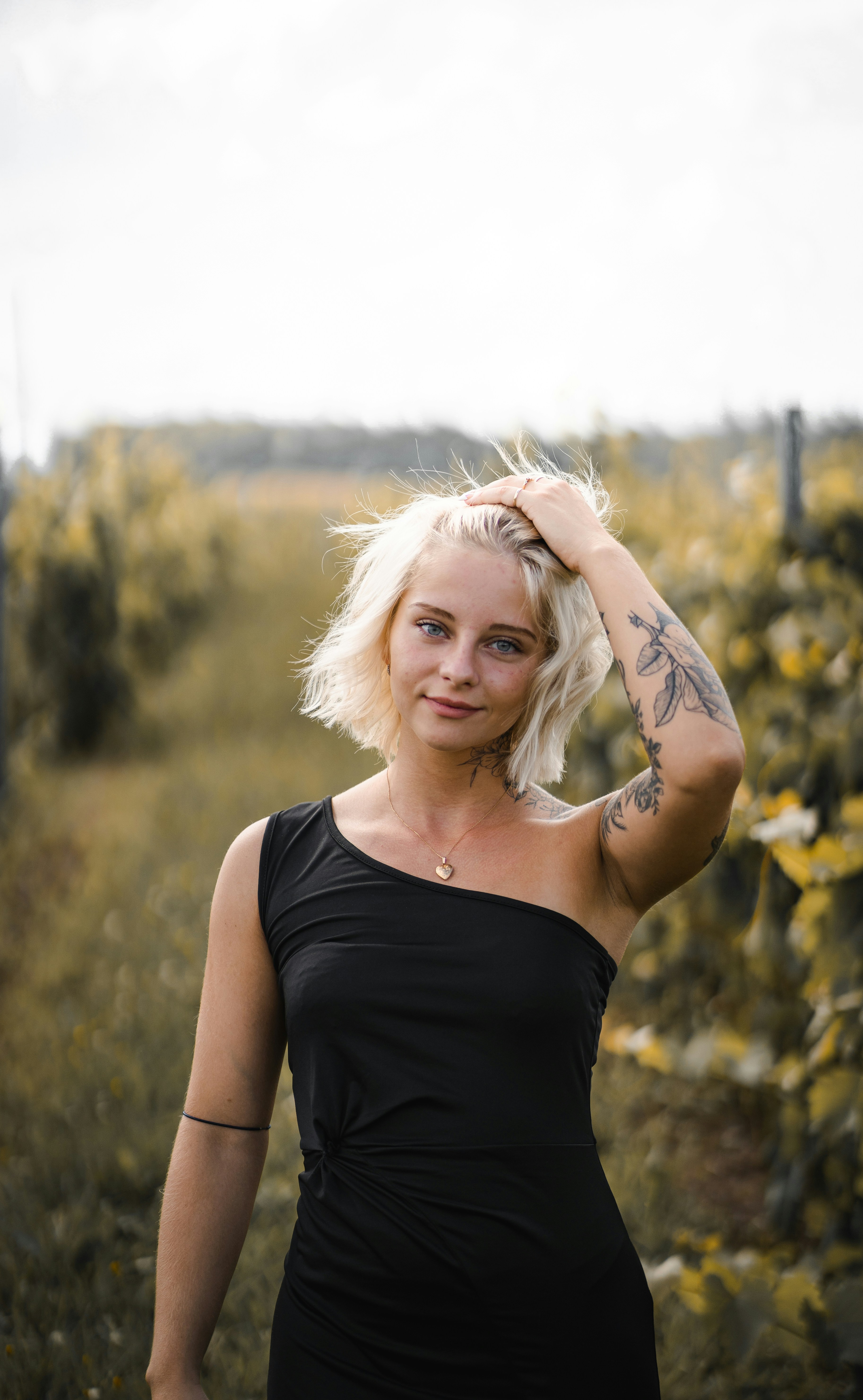 woman in black tank top standing on green grass field during daytime