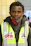 Close-up of a worker wearing a bright yellow customized safety vest with a company logo.