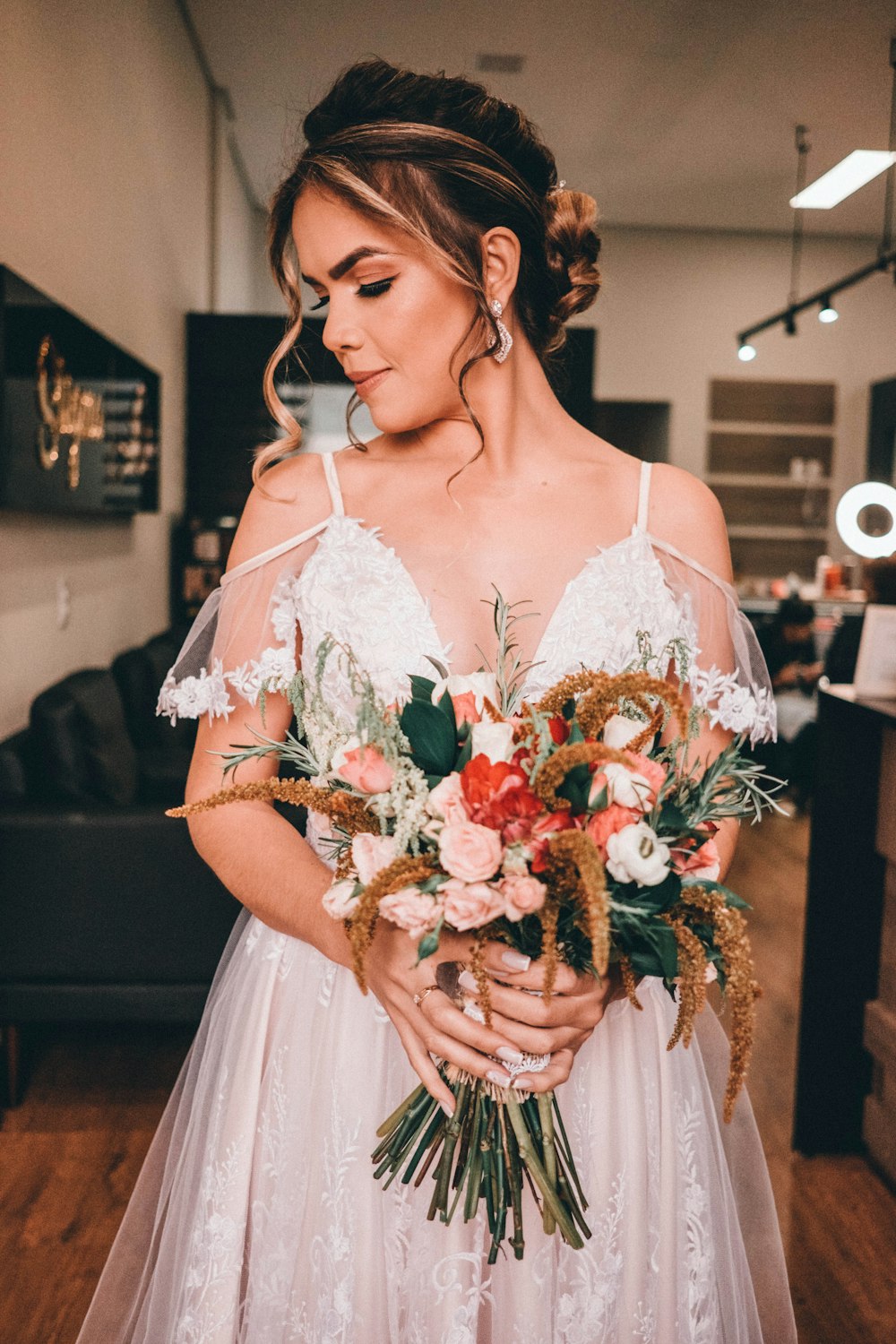 woman in white dress holding bouquet of red roses