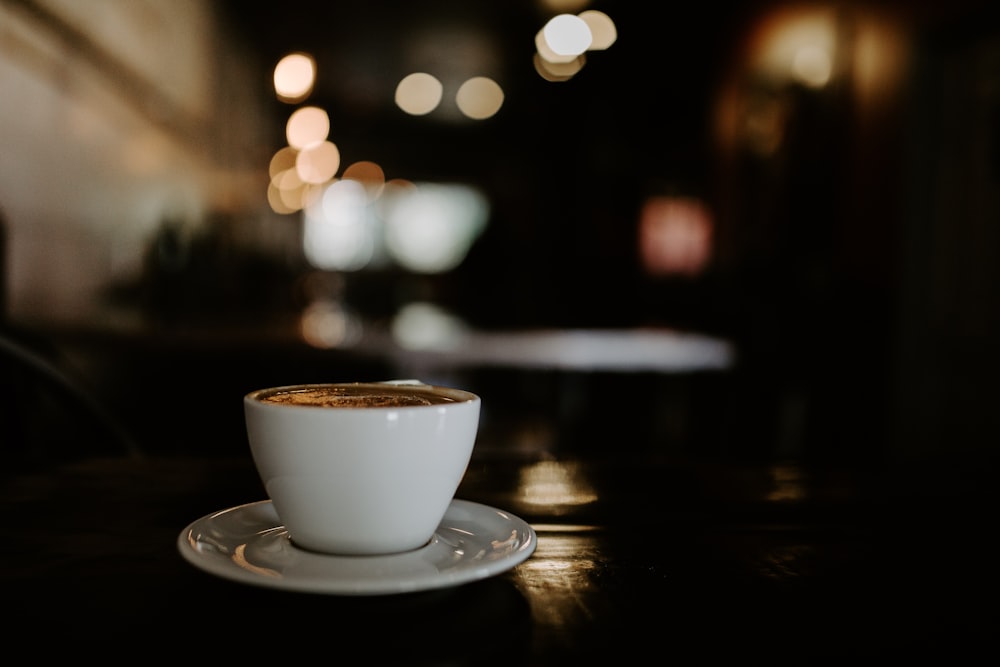 taza de cerámica blanca sobre platillo de cerámica blanca