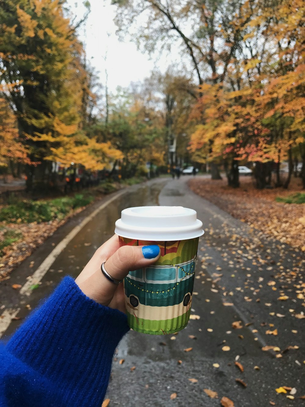 person holding green and white disposable cup